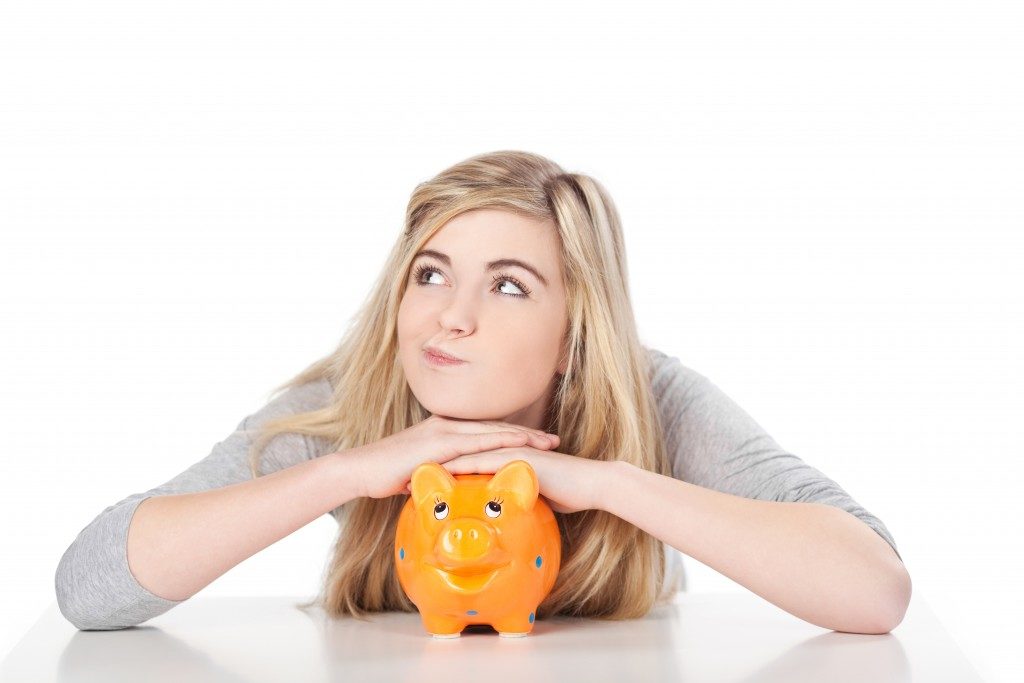 Image of girl posing with piggy bank