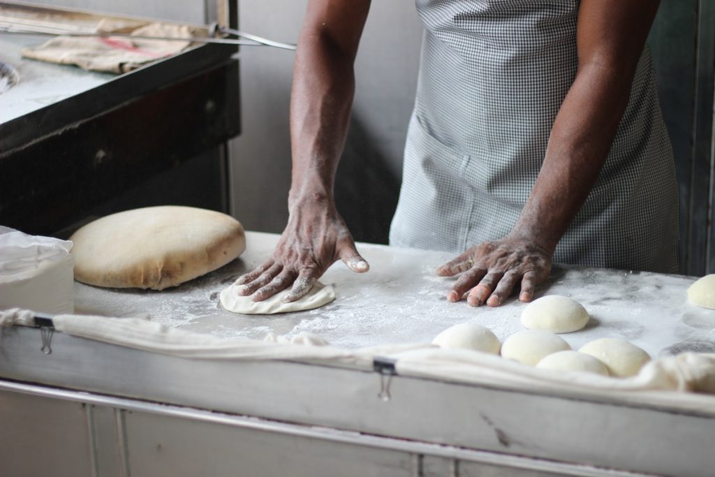 a baker kneading a dough