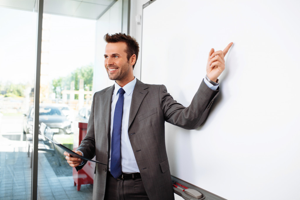 young professional pointing at whiteboard